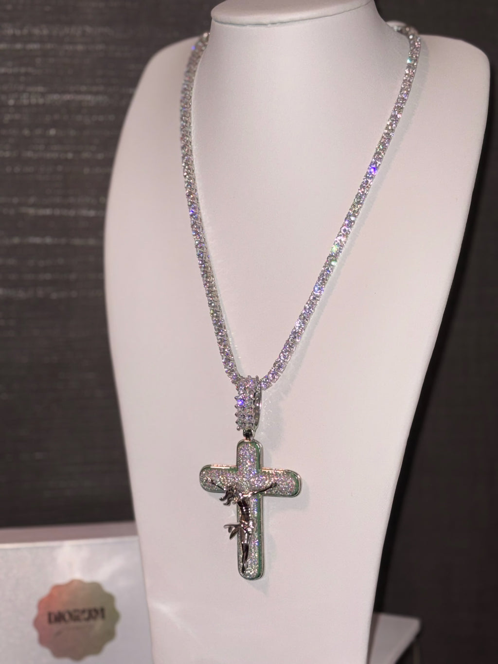 White gold plated tennis chain and icy cross pendant.