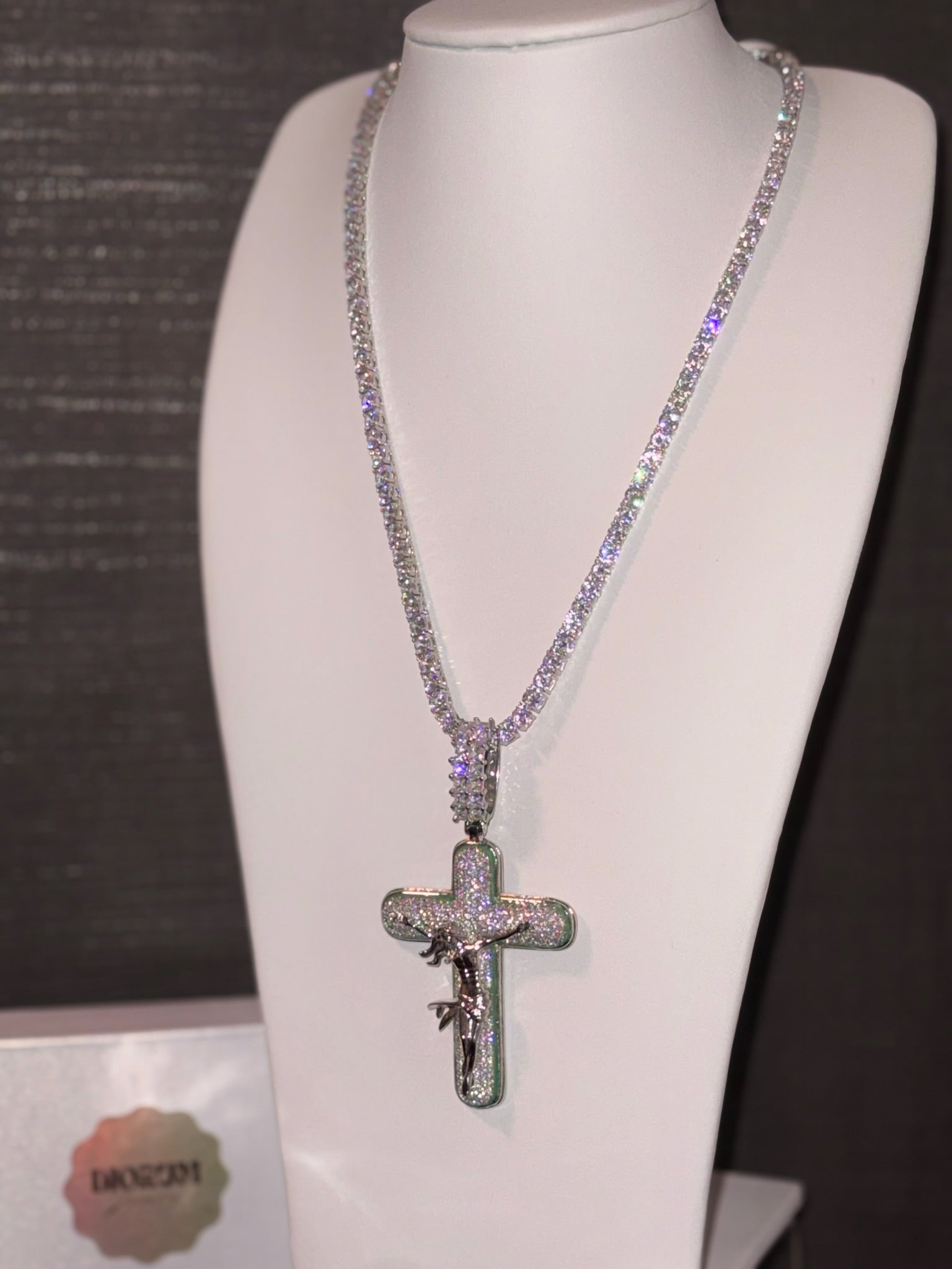 White gold plated tennis chain and icy cross pendant.