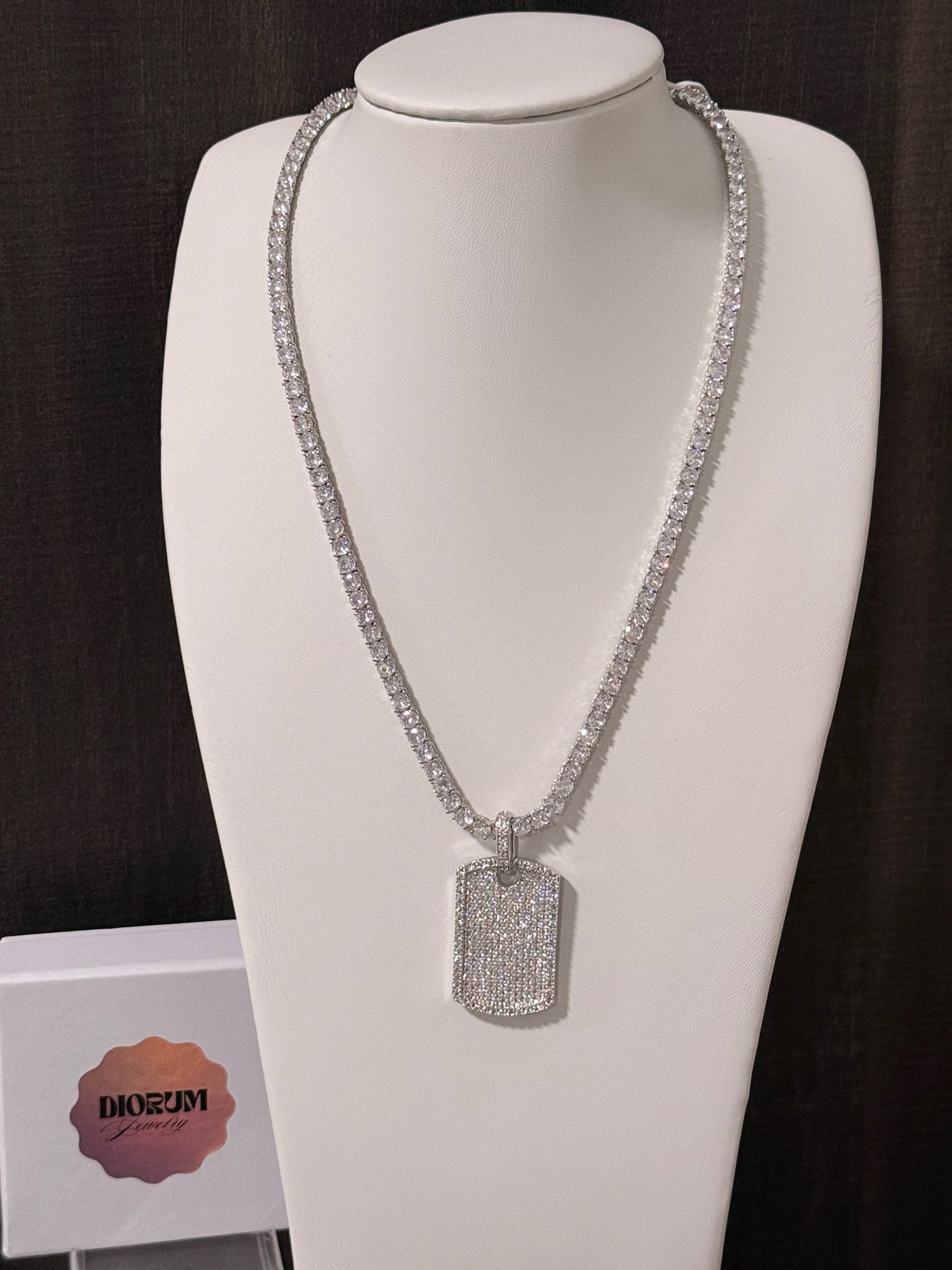 White gold plated tennis necklace and iced tag pendant.