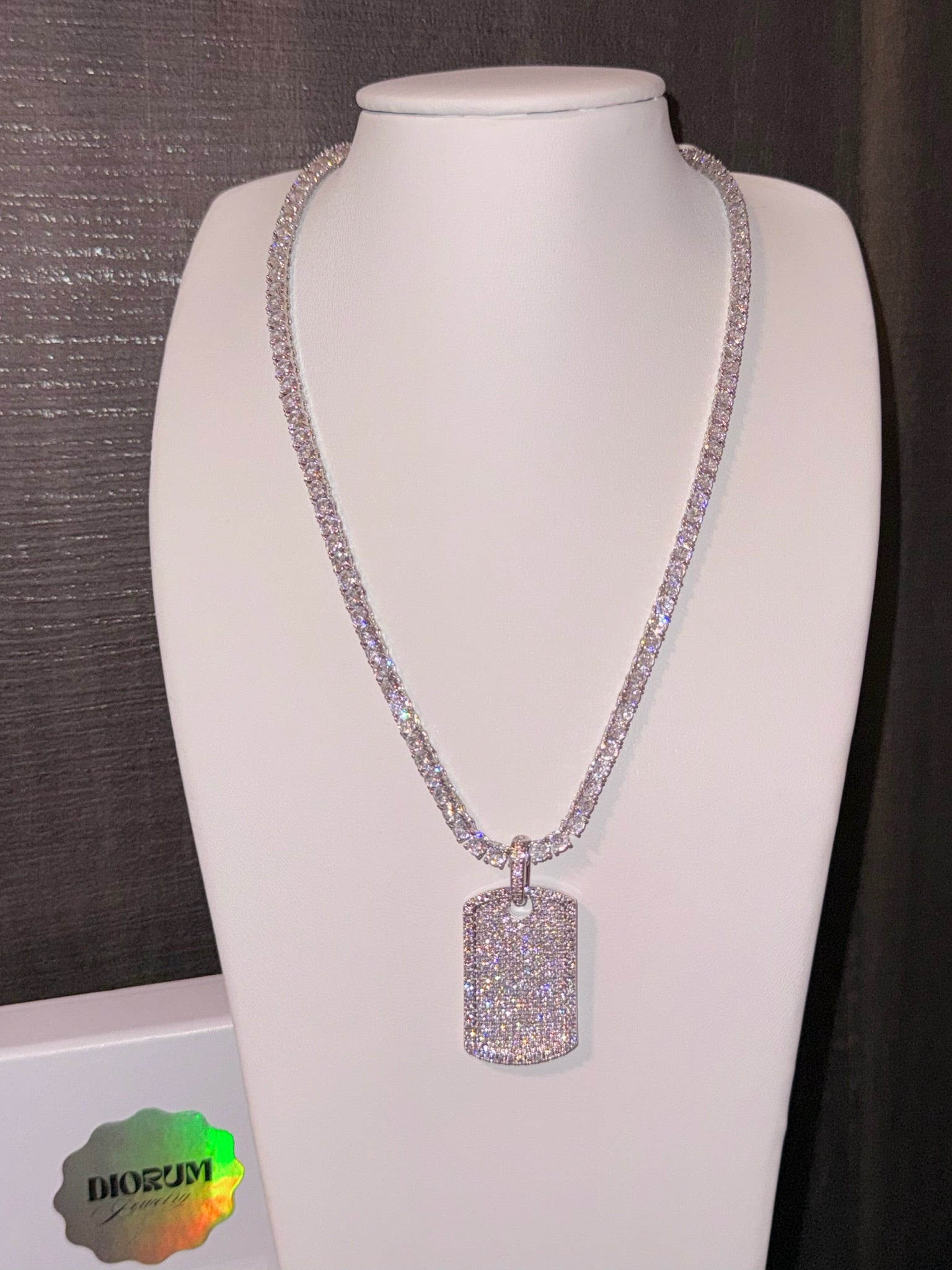 White gold plated tennis necklace and iced tag pendant.